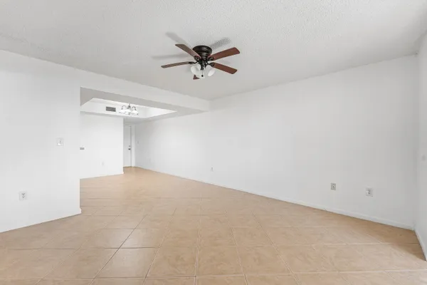 an empty room with a ceiling fan and a window