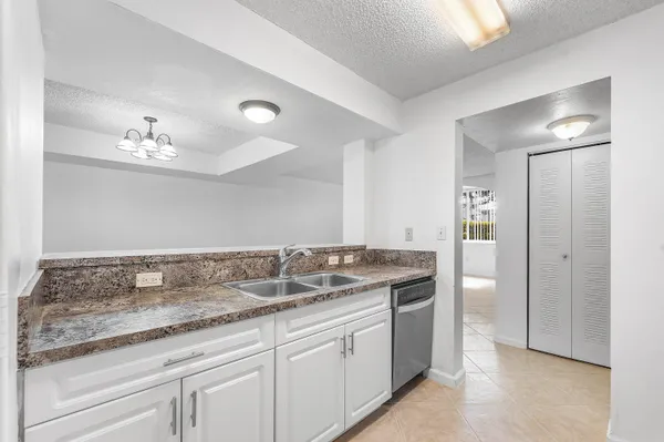 a bathroom with a granite countertop sink a mirror and a shower