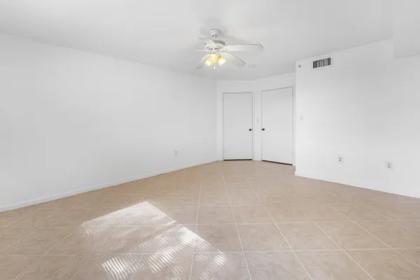 a view of an empty room with a chandelier fan