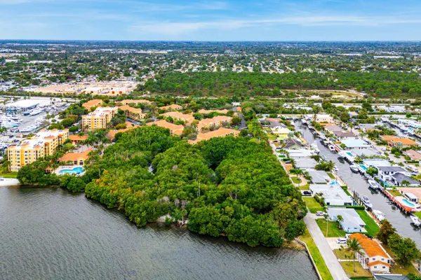 an aerial view of residential houses with outdoor space and trees
