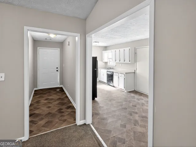 a view of a hallway to kitchen and wooden floor