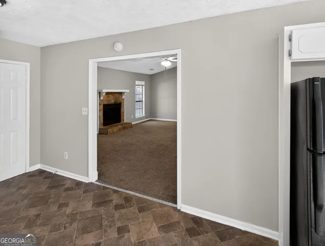 a view of a hallway with a livingroom and a fireplace