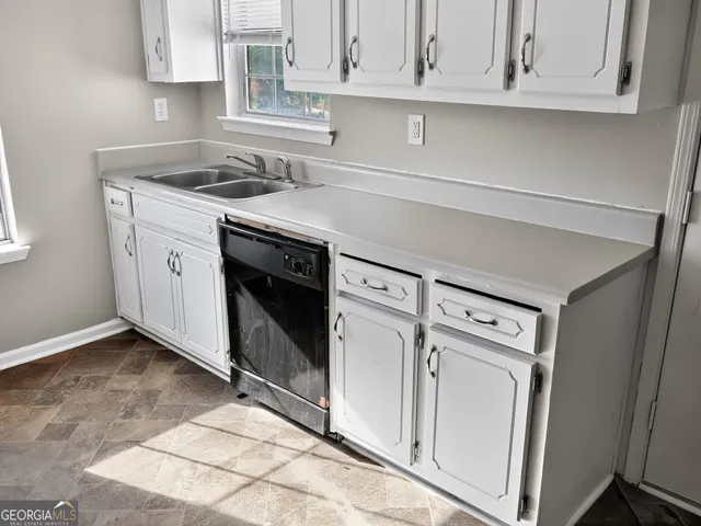 a kitchen with white cabinets and white appliances