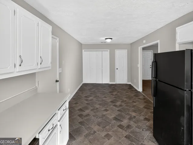 a kitchen with a refrigerator and cabinets