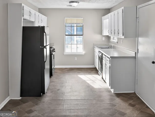 a view of kitchen with refrigerator and window