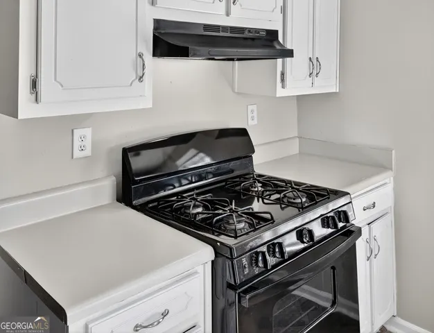 a stove top oven sitting inside of a kitchen