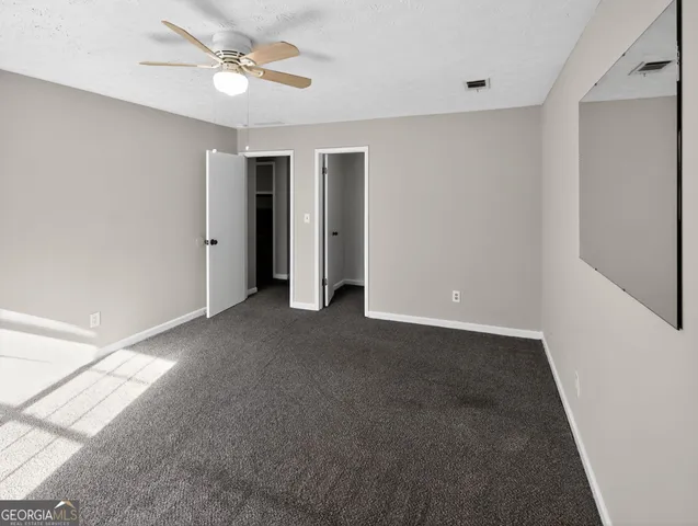 a view of an empty room with a ceiling fan