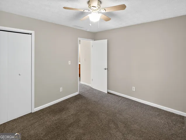 an empty room and chandelier fan