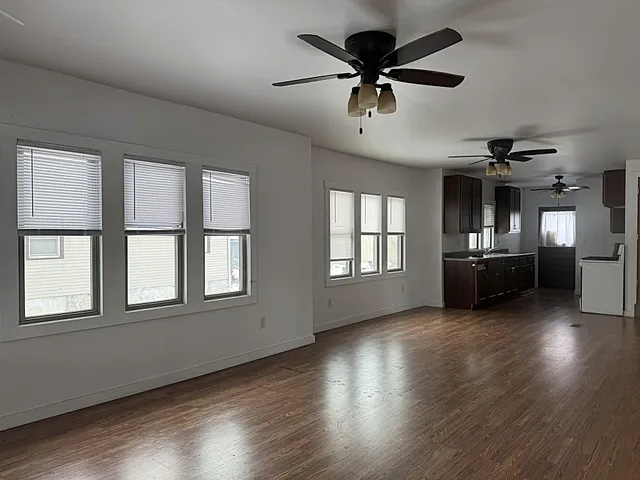 a view of a livingroom with wooden floor and a ceiling fan