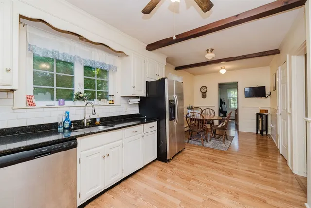 a kitchen with granite countertop a sink appliances cabinets and dining table