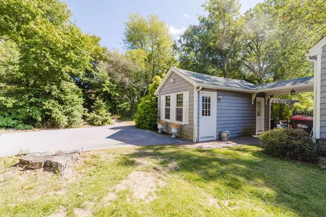 a view of a house with a yard and large tree