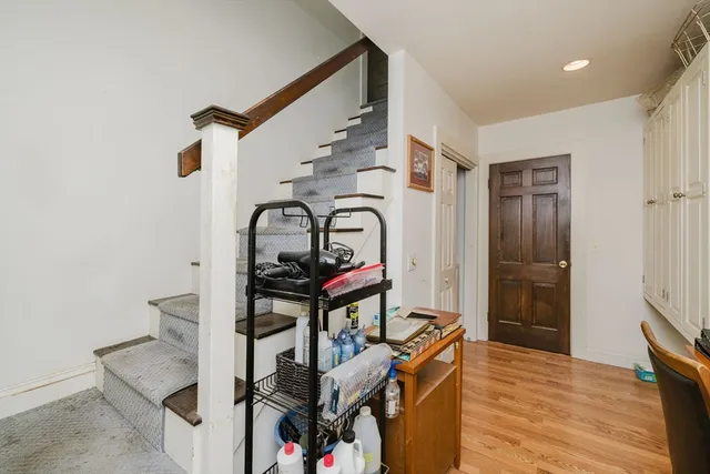a view of a hallway with wooden floor and staircase
