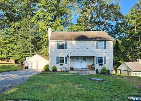a front view of a house with a yard and trees