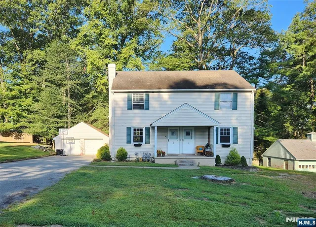 a front view of a house with a yard and trees