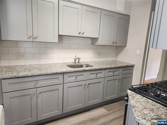 a kitchen with stainless steel appliances wooden cabinet and a stove top oven