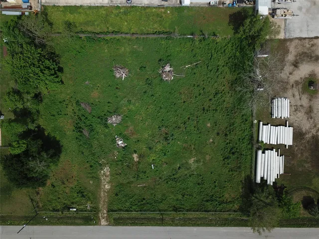 an aerial view of residential houses with outdoor space and trees