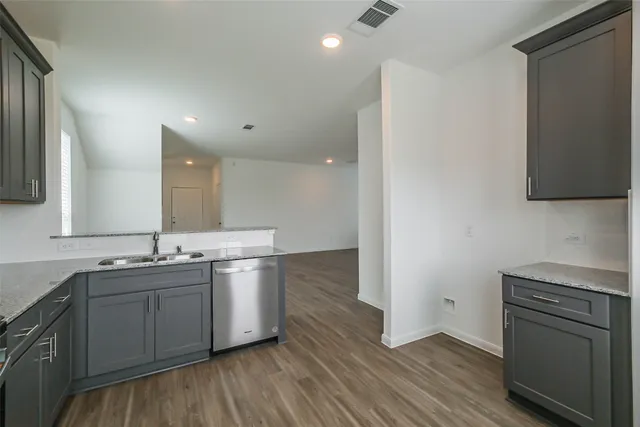 a kitchen with a sink cabinets stainless steel appliances and a window