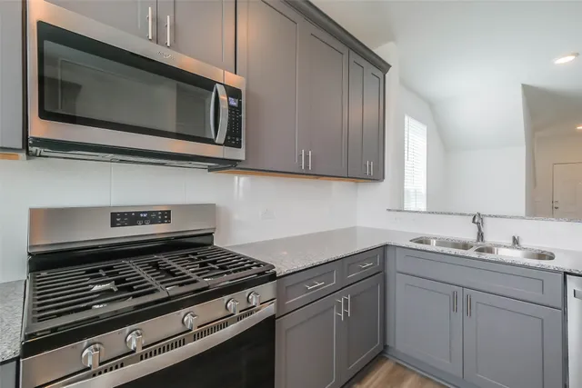 a kitchen with stainless steel appliances a sink a stove and microwave