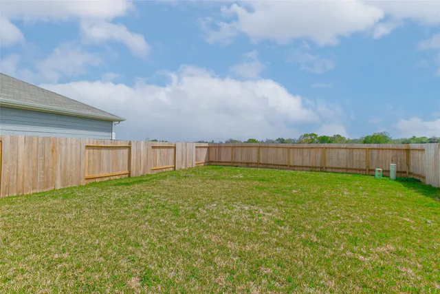 a view of a backyard with barn and wooden fence