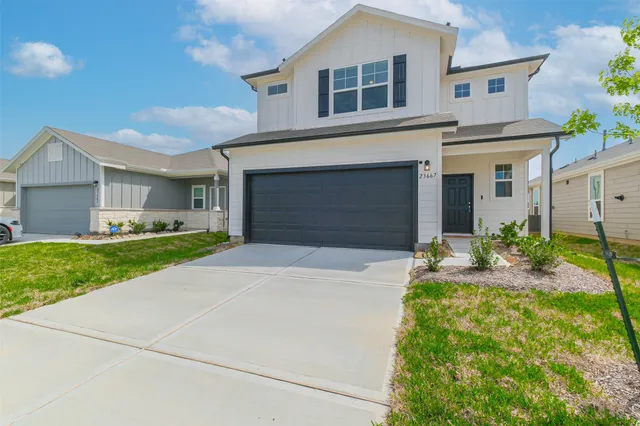a front view of a house with a garden and yard