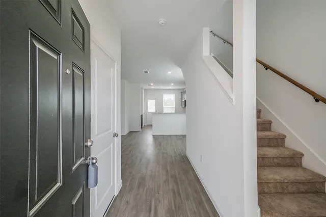 a view of a hallway with wooden floor and staircase