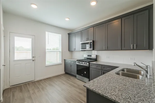 a kitchen with a sink stove and cabinets
