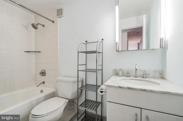 a bathroom with a sink toilet vanity and shower