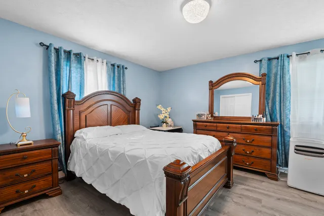 a bedroom with a large bed and a flat tv screen on dresser
