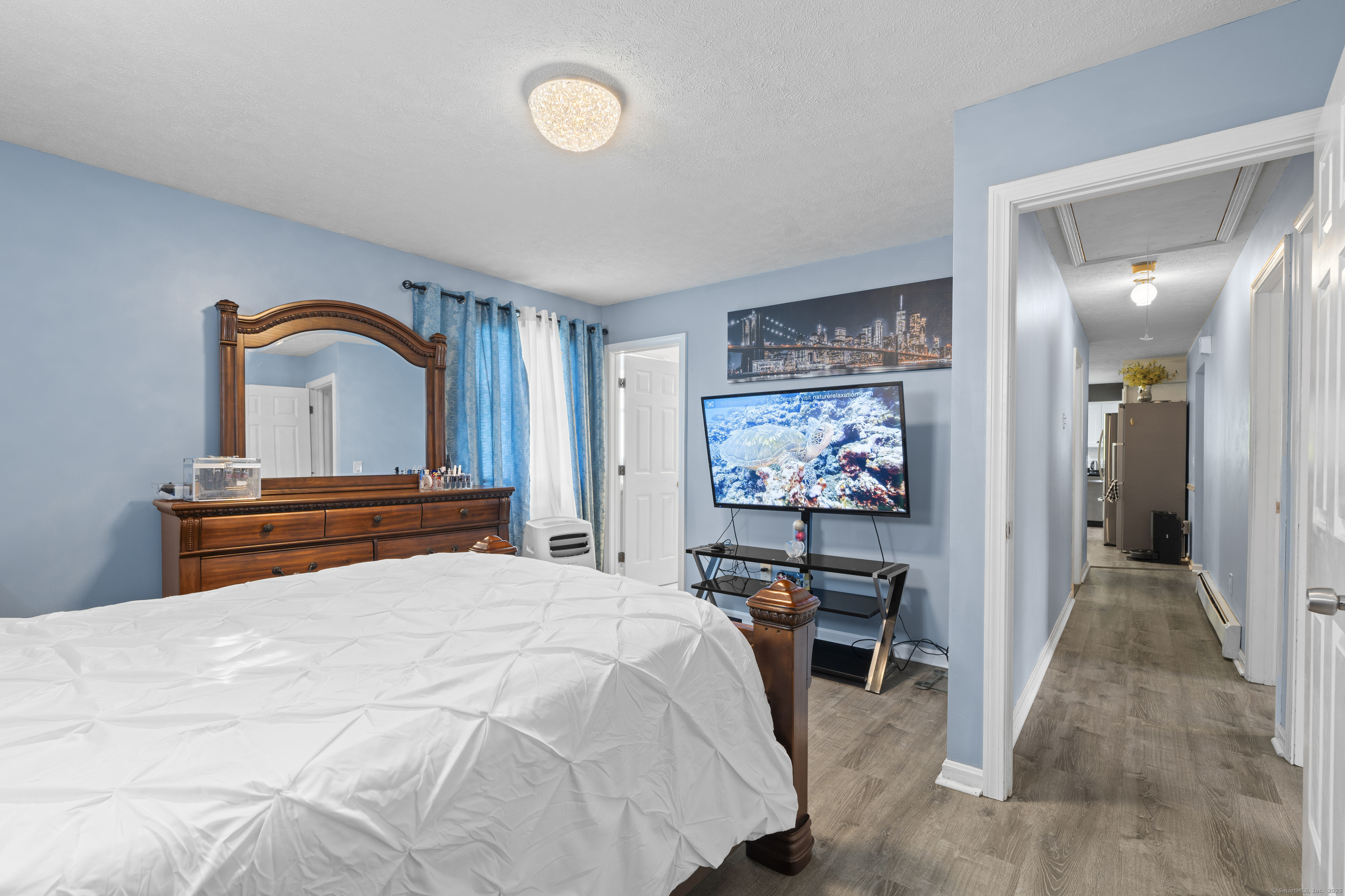 63 Johl Drive Groton, CT 06340 - Photo 18 of 40 a bedroom with a large bed and a flat tv screen on dresser