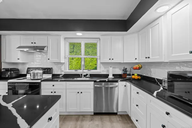 a kitchen with a sink a stove and cabinets