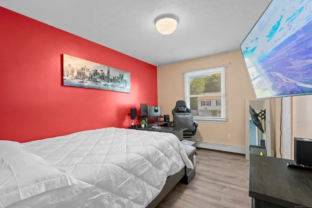 a bedroom with a bed and wooden floor