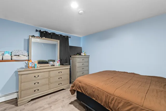 a room with a wooden floor and white cabinet