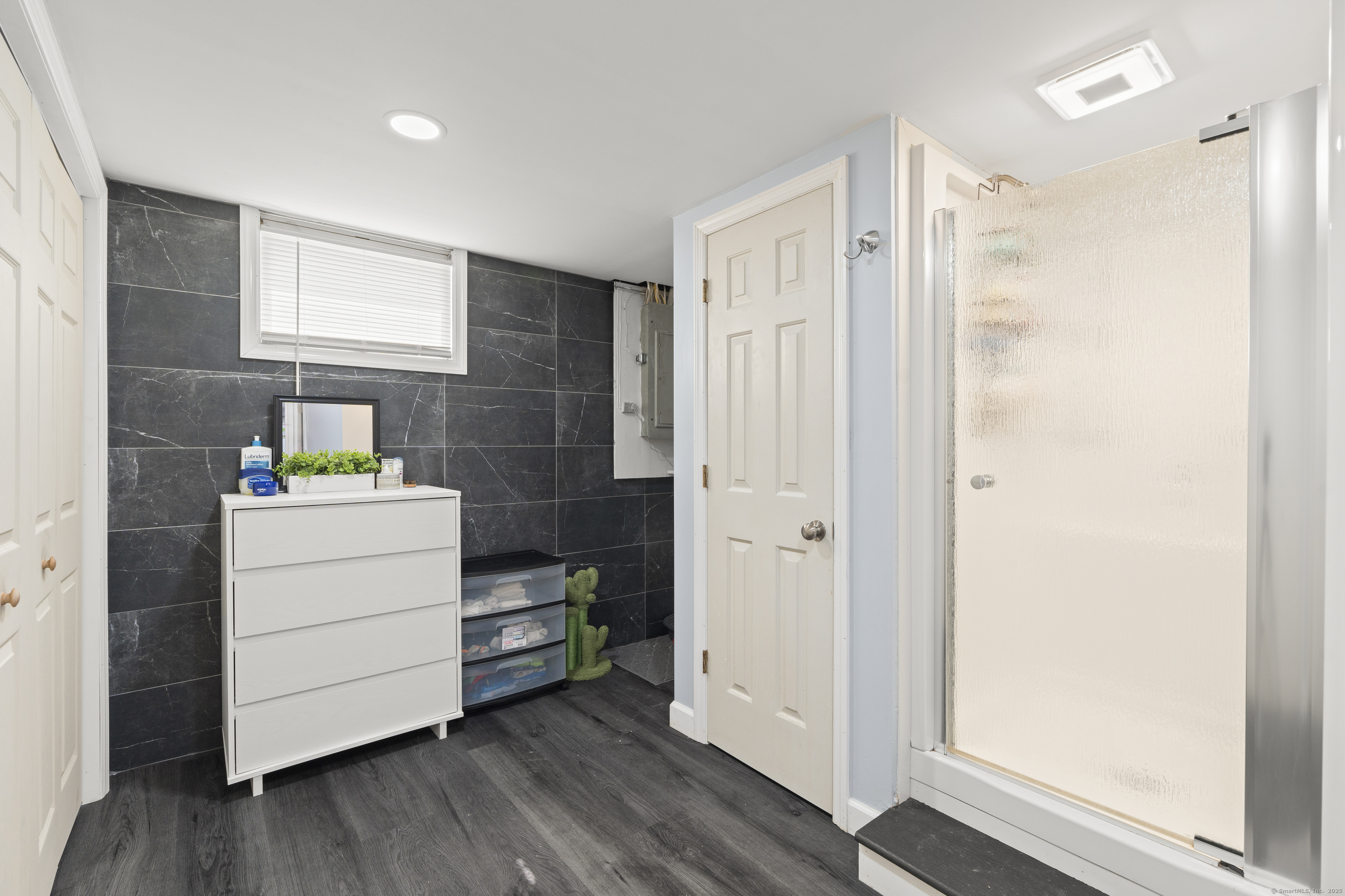 63 Johl Drive Groton, CT 06340 - Photo 40 of 40 a room with a wooden floor and white cabinet