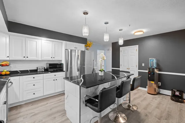 a kitchen with granite countertop a sink a stove and white cabinets