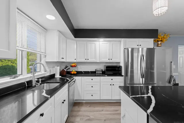 a kitchen with stainless steel appliances a sink a stove and a refrigerator