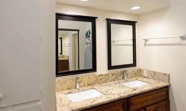 a bathroom with a granite countertop sink and a mirror