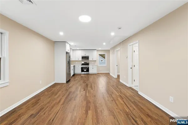 a view of empty room with wooden floor