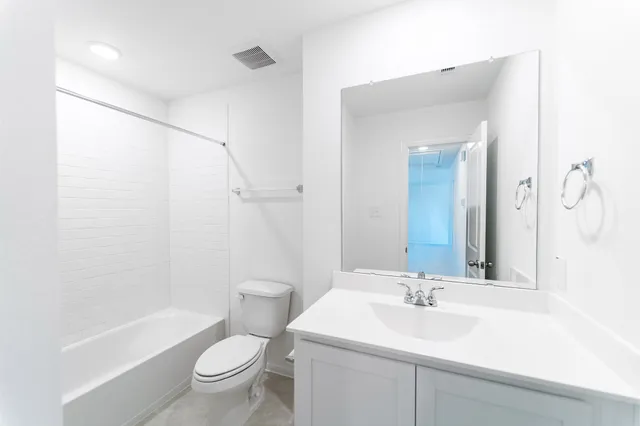 a bathroom with a sink a toilet and a large mirror