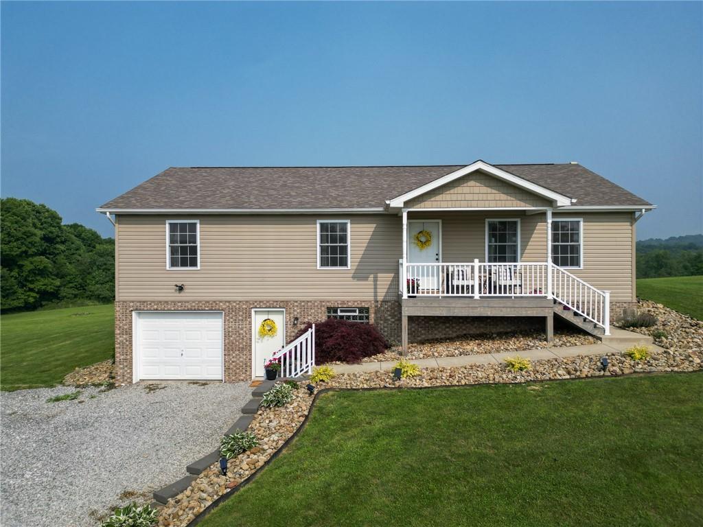 667 Ridge Road Georgetown, PA 15043 - Photo 1 of 27 a front view of a house with a garden and chairs
