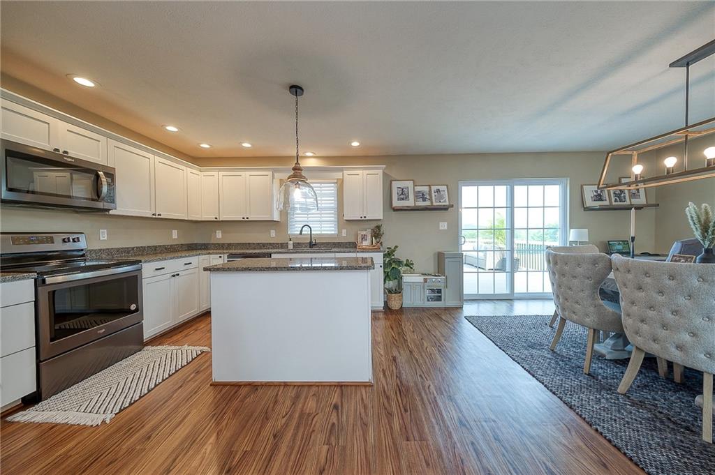 667 Ridge Road Georgetown, PA 15043 - Photo 5 of 27 a kitchen with stainless steel appliances granite countertop wooden floors a stove and a microwave