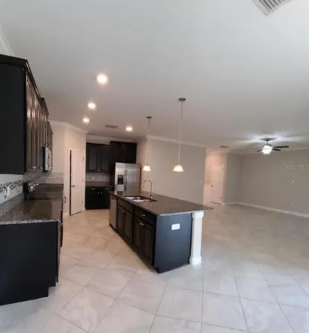 a large kitchen with a large counter top and stainless steel appliances