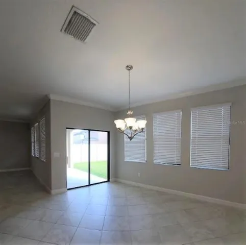 a view of a livingroom with a chandelier fan and windows
