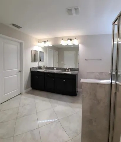 a large bathroom with a double vanity sink and mirror