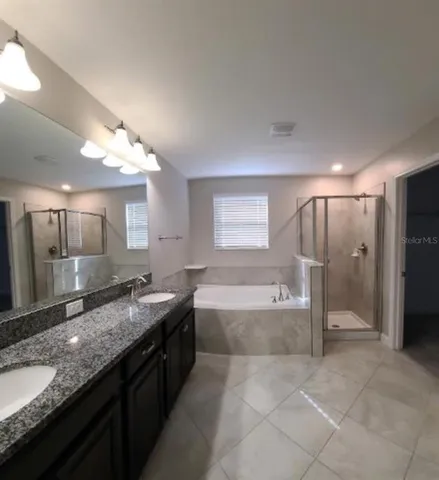 a bathroom with a granite countertop bathtub sink and mirror