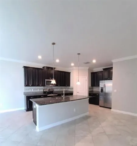 a kitchen with stainless steel appliances granite countertop a stove refrigerator and a sink