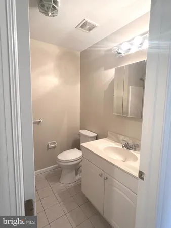 a bathroom with a granite countertop sink toilet and mirror