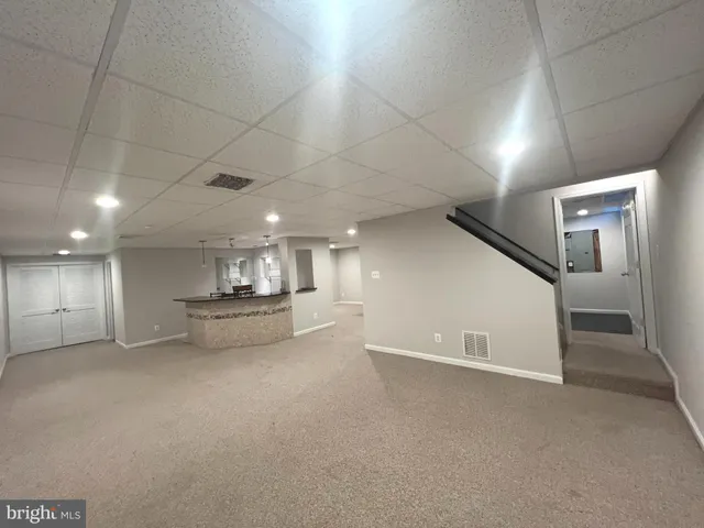 a view of empty room with kitchen and window
