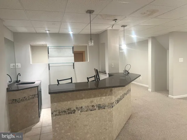 a bathroom with a granite countertop sink a mirror and shower