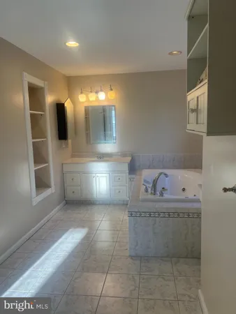 a bathroom with a bathtub sink and mirror