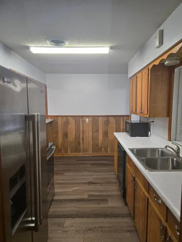 a kitchen with kitchen island a sink and refrigerator